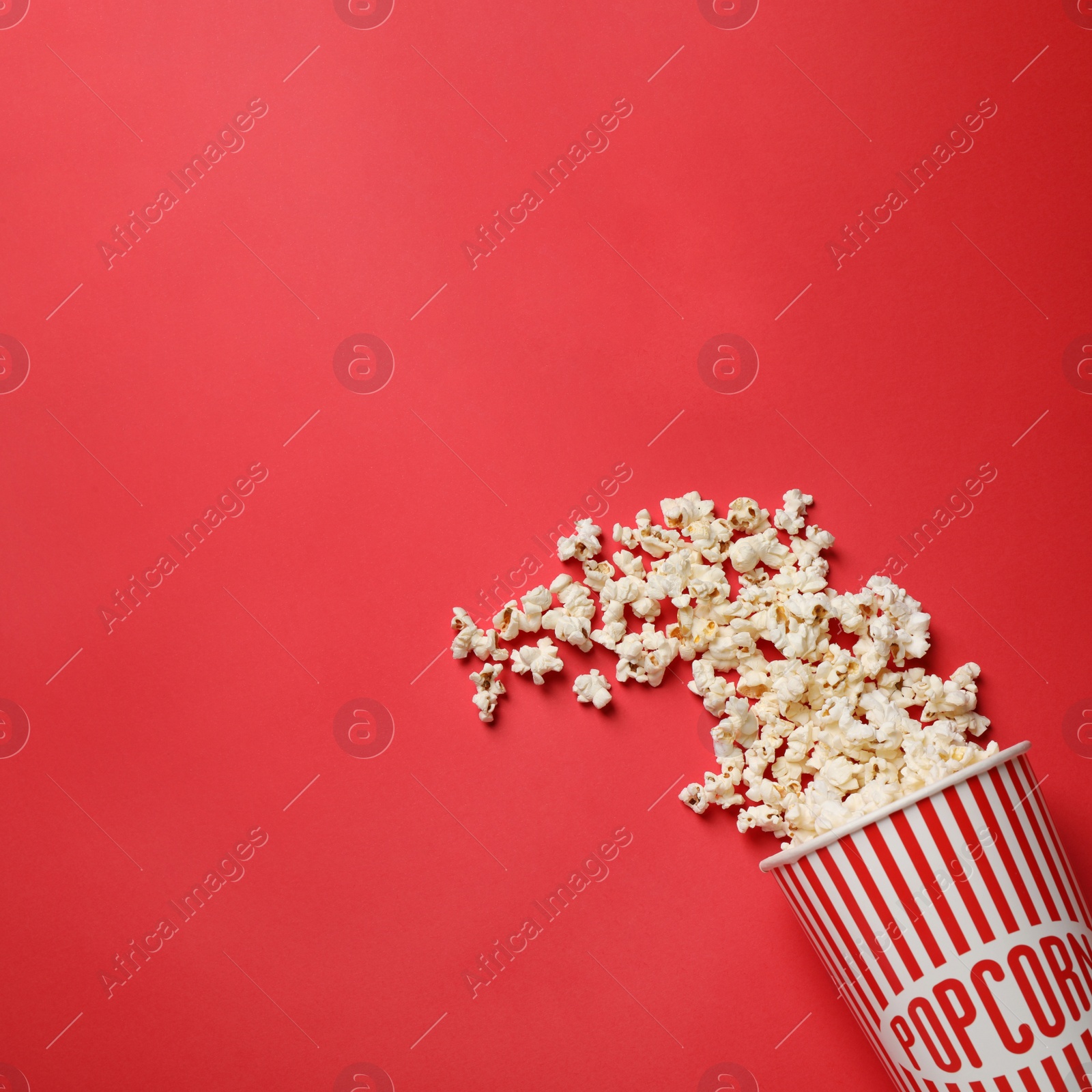 Photo of Delicious popcorn on red background, top view. Space for text