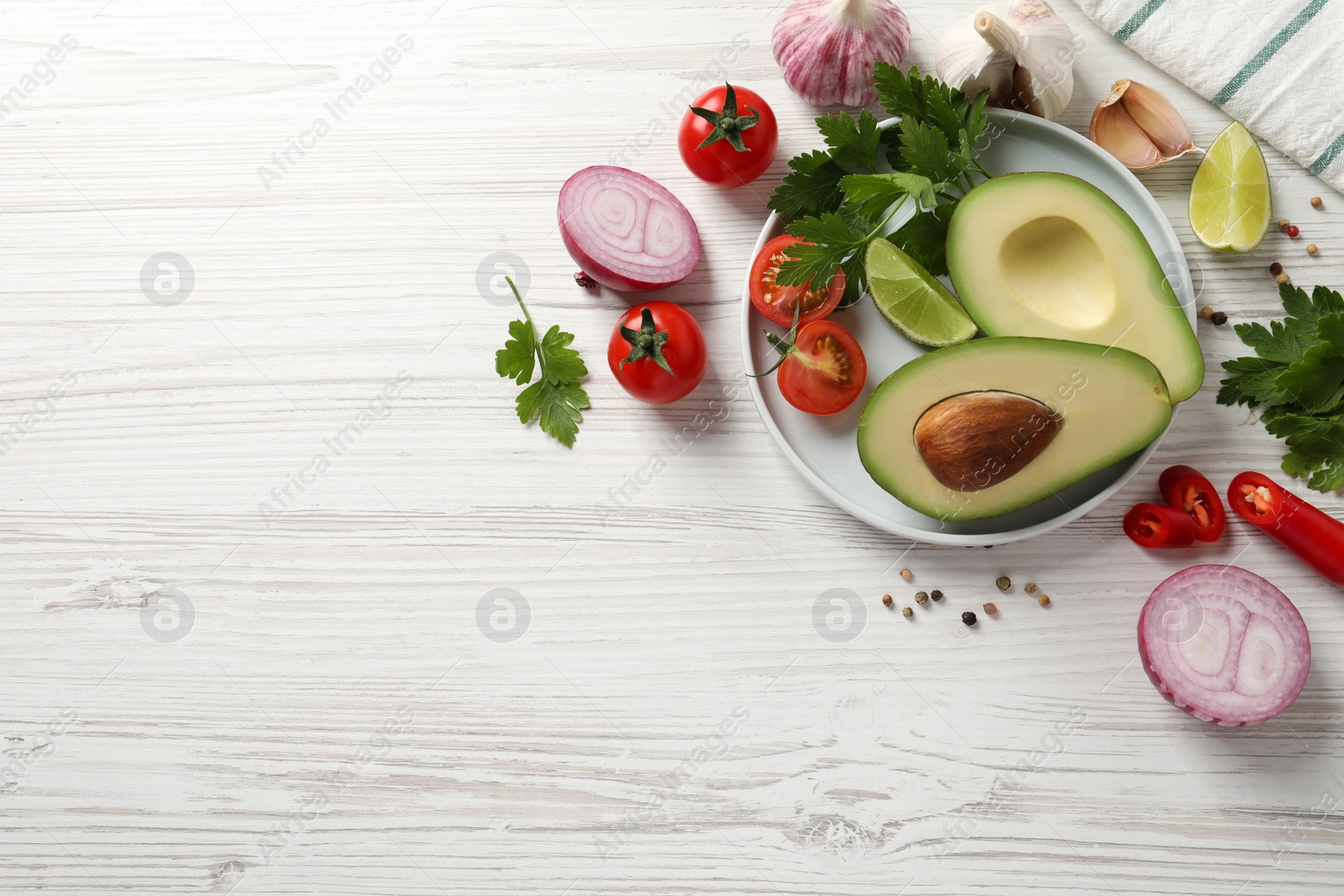 Photo of Fresh guacamole ingredients on white wooden table, flat lay. Space for text