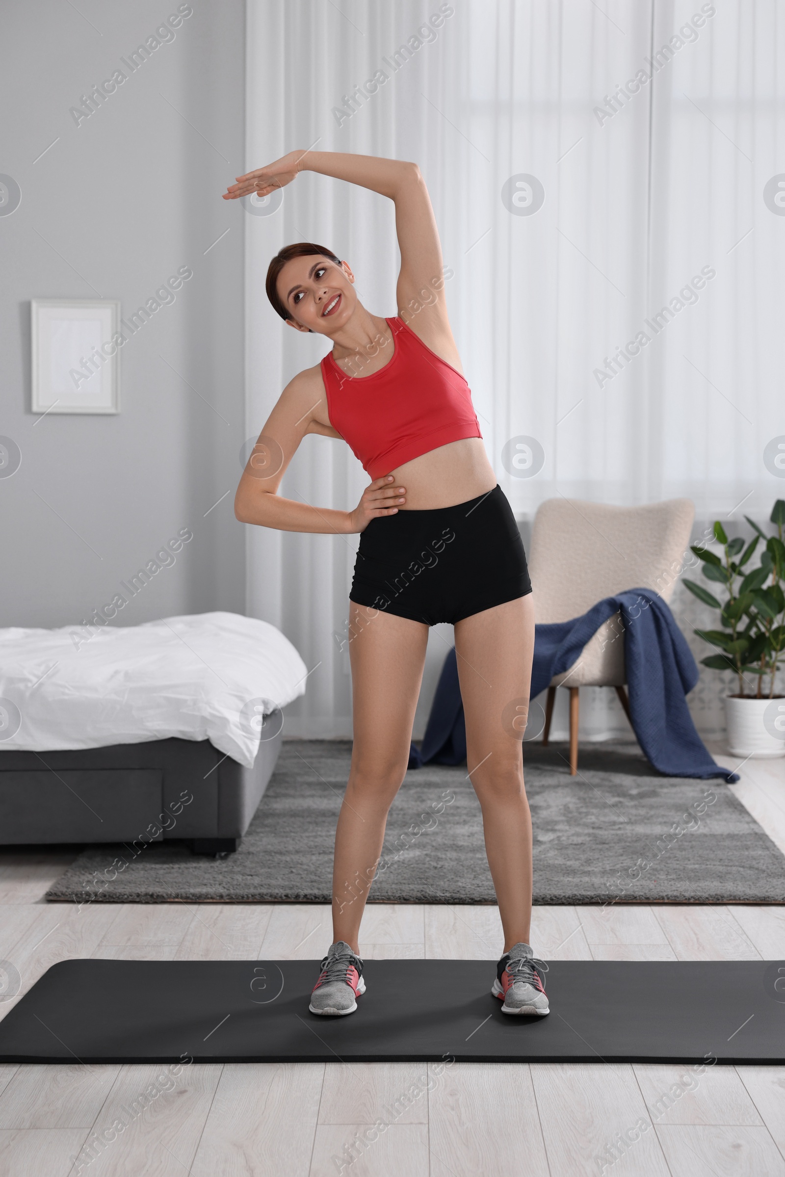 Photo of Morning routine. Happy woman stretching at home