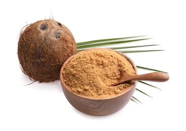 Photo of Coconut sugar in bowl, spoon, fruit and palm leaf isolated on white