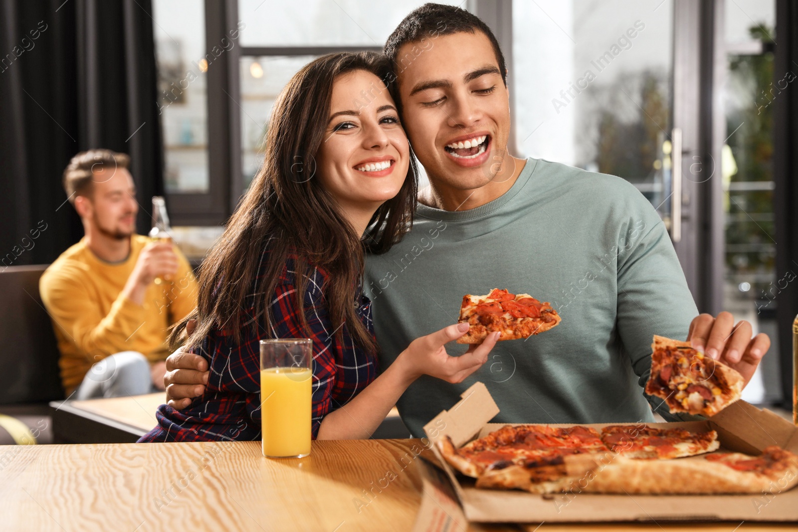 Photo of Young couple eating delicious pizza in cafe