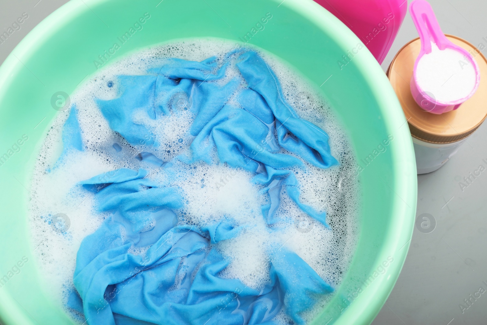 Photo of Color clothes with foam in basin, top view