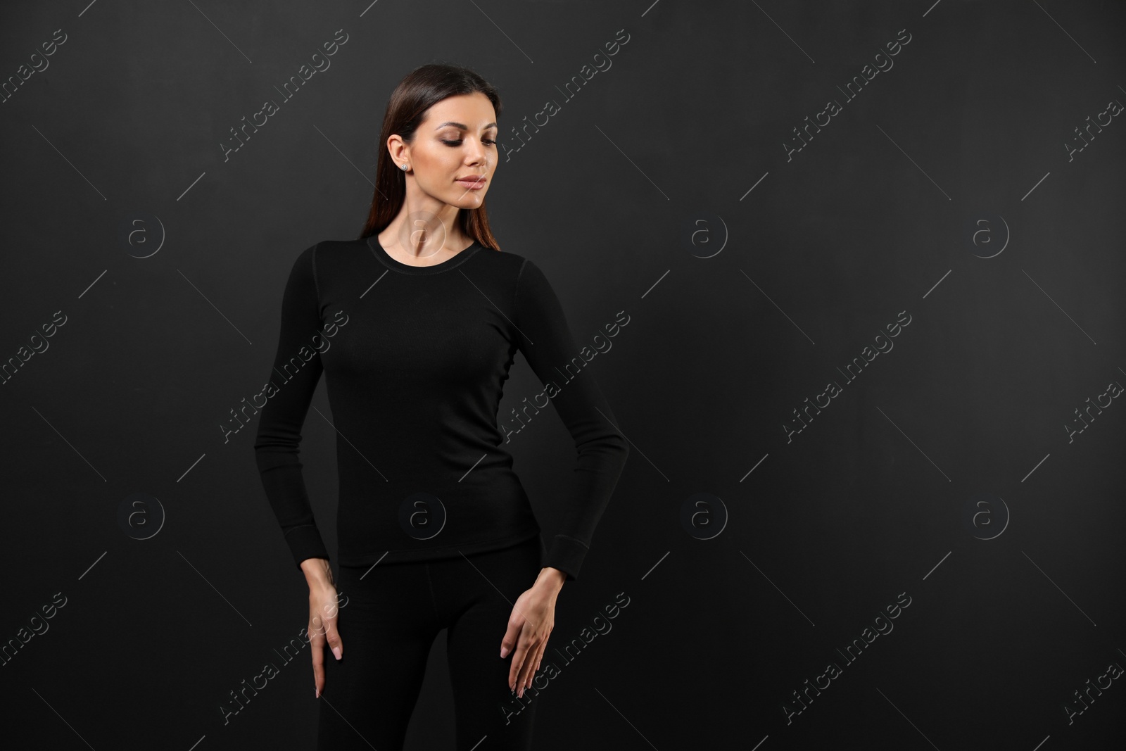 Photo of Woman wearing thermal underwear on black background. Space for text