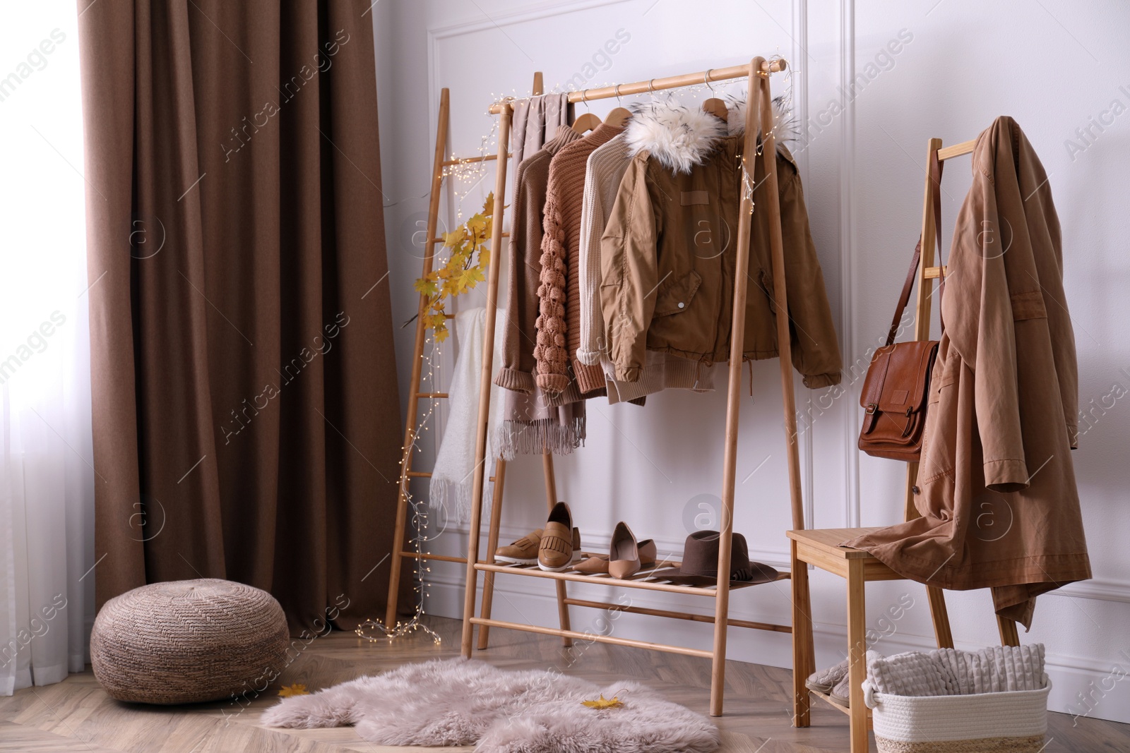 Photo of Rack with stylish warm clothes, shoes and accessories in modern dressing room