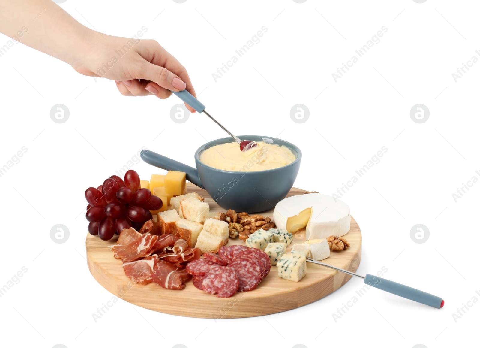 Photo of Woman dipping grape into fondue pot with melted cheese on white background, closeup