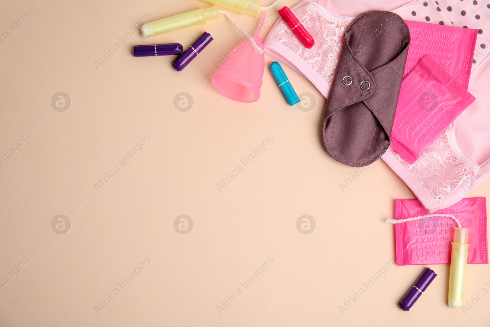 Photo of Tampons and other menstrual hygienic products on beige background, flat lay. Space for text