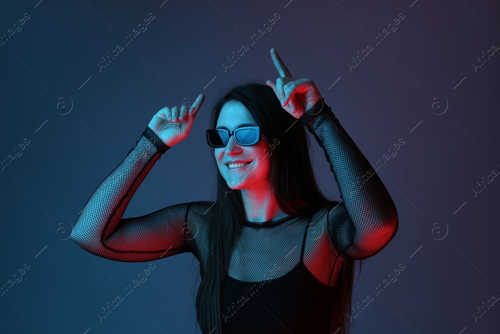 Photo of Portrait of beautiful young woman with sunglasses on color background