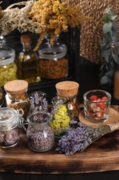 Photo of Many different herbs and dry lavender flowers on wooden table