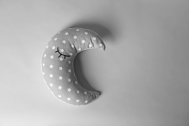 Soft pillow in shape of moon on light background