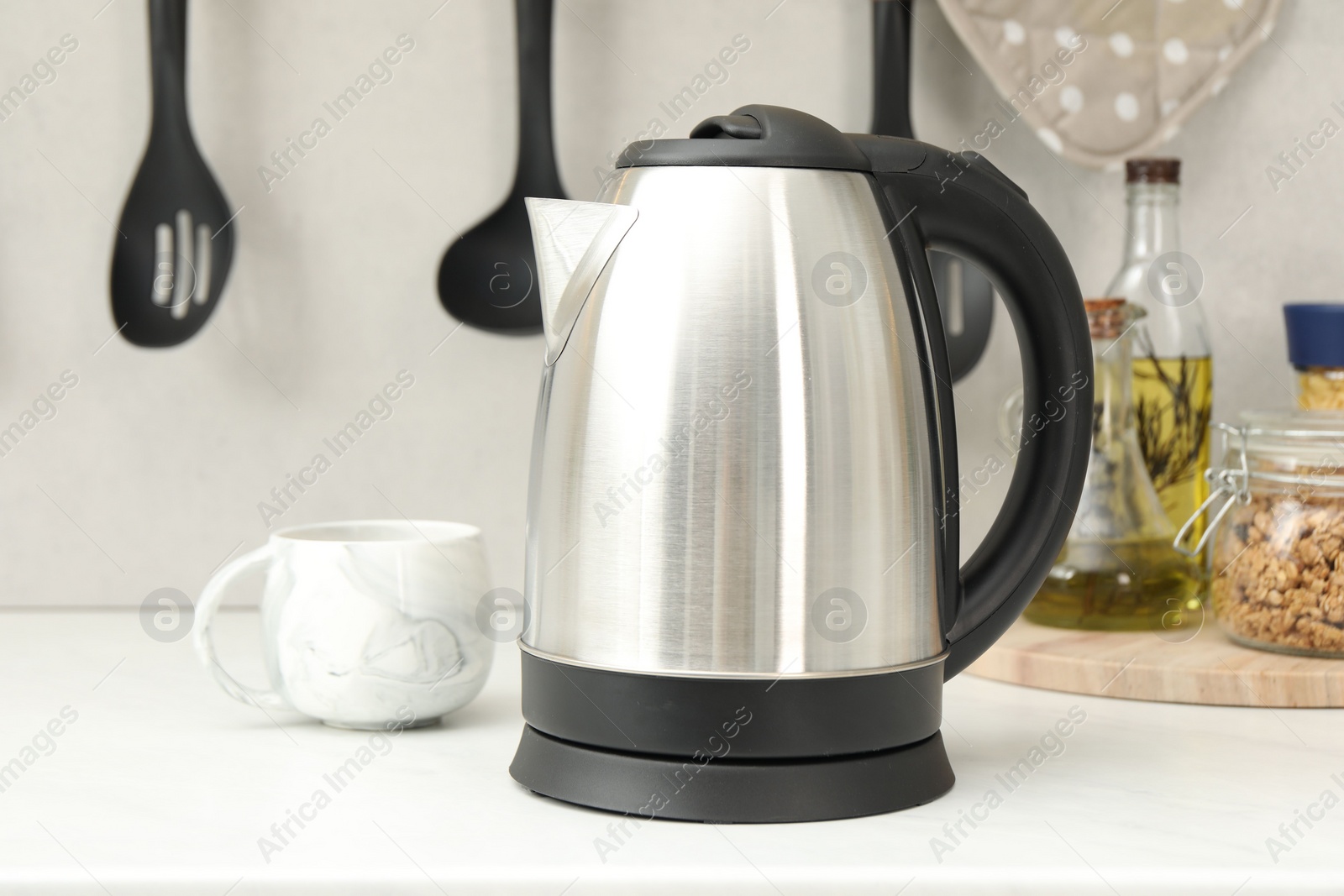 Photo of Electric kettle and cup on counter in kitchen