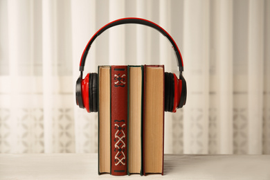 Photo of Books and headphones on white wooden table