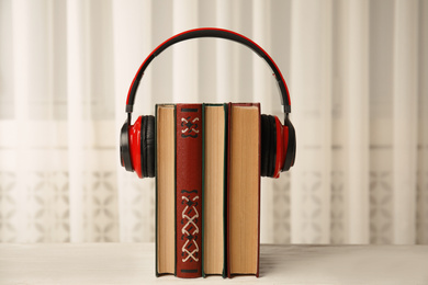 Books and headphones on white wooden table