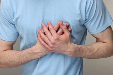 Photo of Man suffering from heart hurt on grey background, closeup