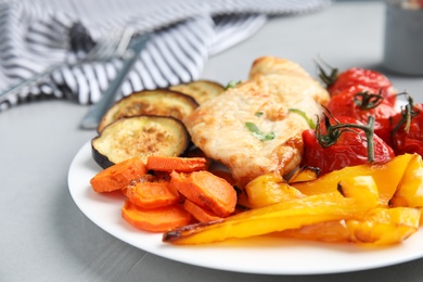Photo of Delicious cooked chicken and vegetables on grey table, closeup. Healthy meals from air fryer