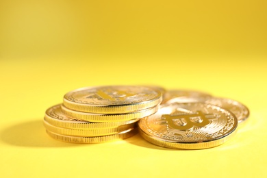 Photo of Shiny bitcoins on yellow background. Digital currency