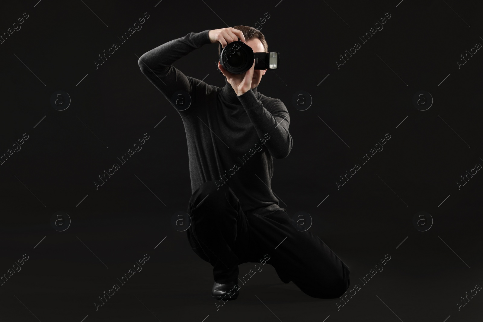 Photo of Professional photographer taking picture on black background