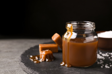 Photo of Delicious salted caramel on light grey table