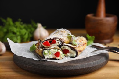 Photo of Delicious baked eggplant rolls served on wooden table