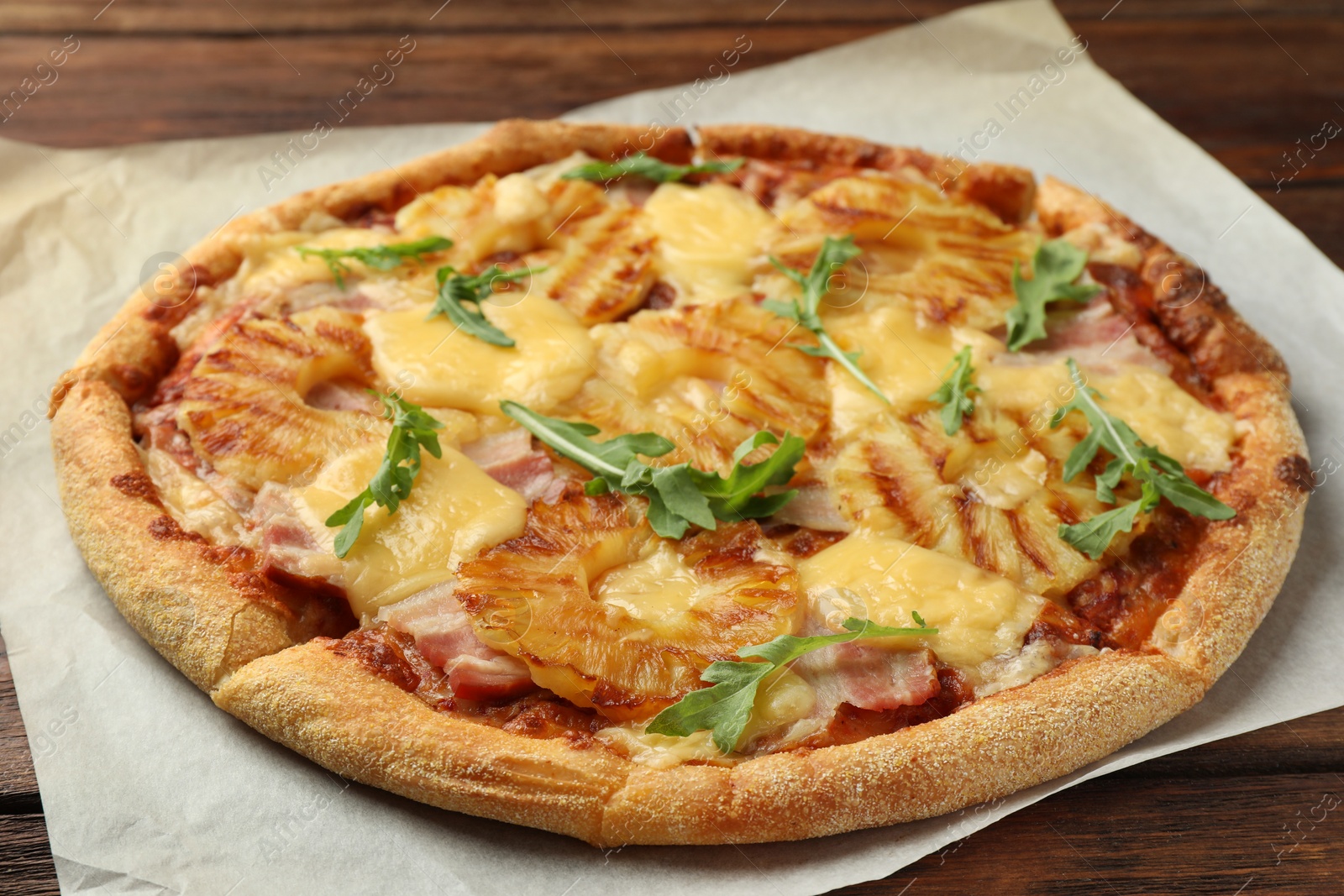 Photo of Delicious pineapple pizza with arugula on table, closeup