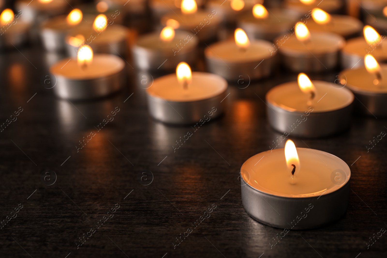 Photo of Burning candles on wooden table, space for text. Symbol of sorrow