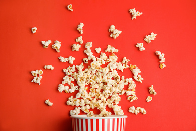 Photo of Tasty pop corn on red background, flat lay