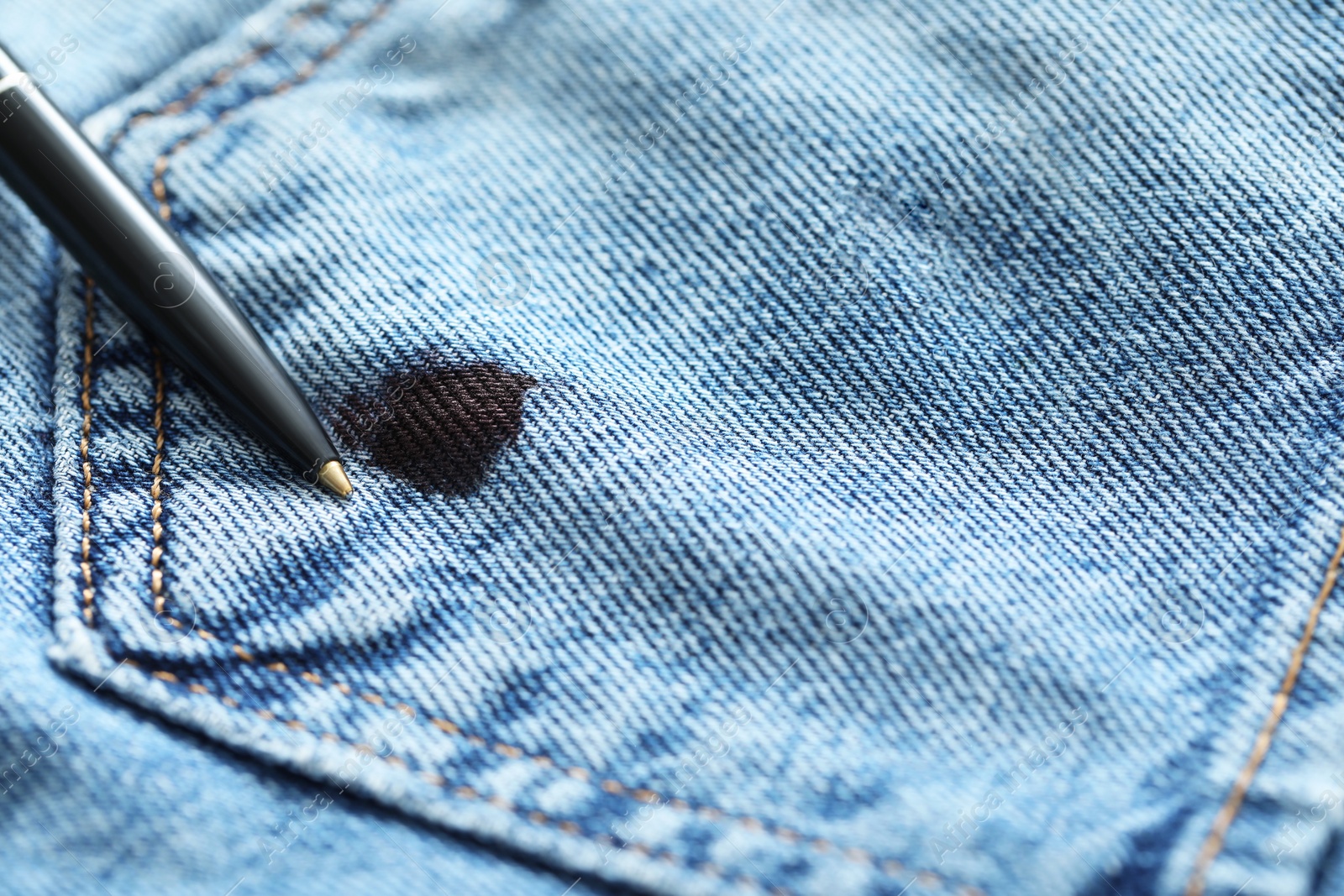 Photo of Pen and stain of black ink on jeans, closeup. Space for text