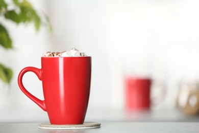 Cup of tasty cocoa with marshmallows on table indoors. Space for text