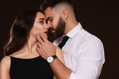 Photo of Handsome bearded man with sexy lady on dark brown background