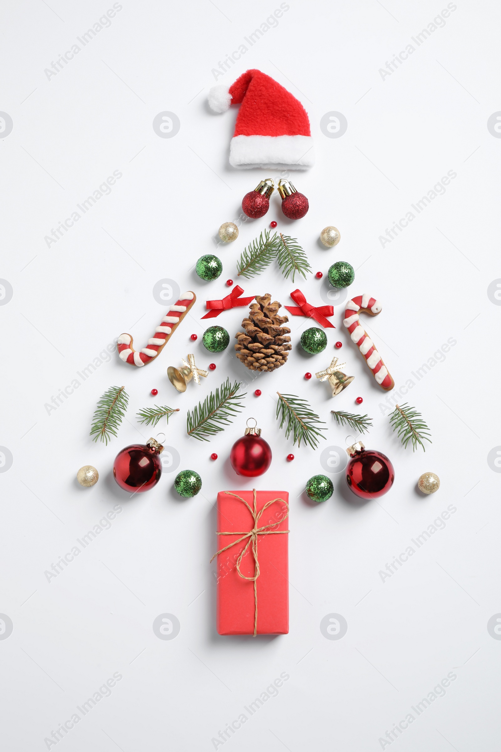 Photo of Christmas tree silhouette of fir branches and festive decoration on white background, top view