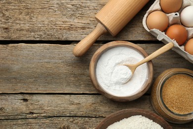 Photo of Ingredients for making dough and rolling pin on wooden table, flat lay. Space for text