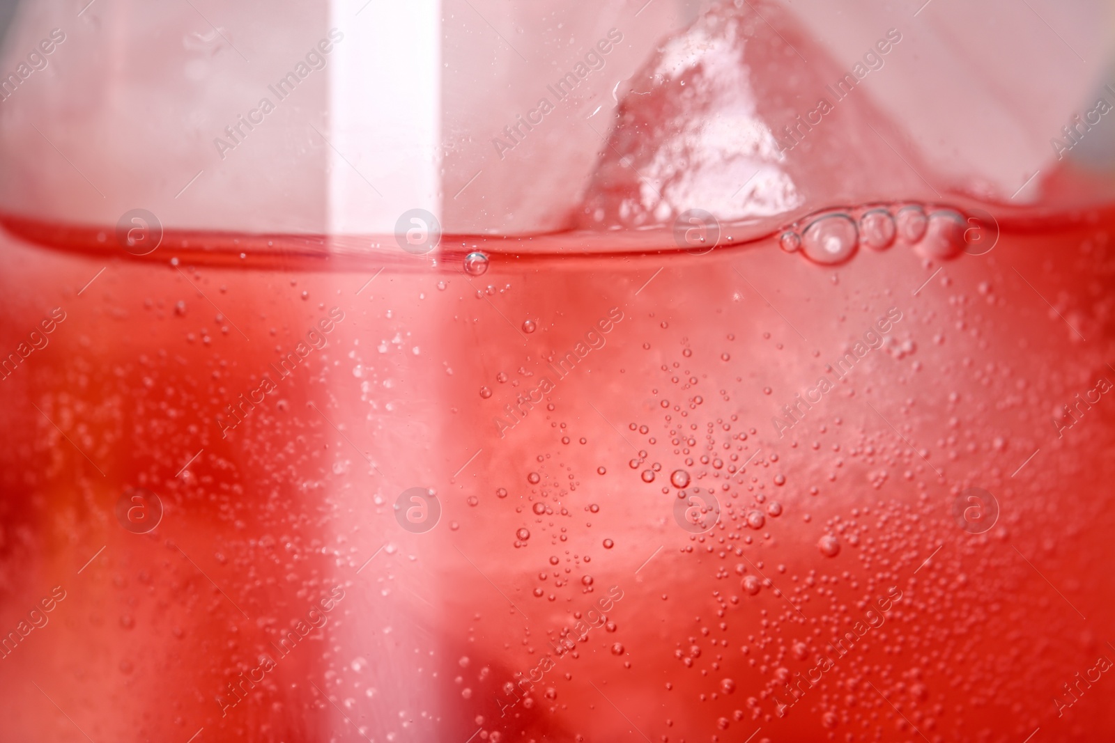 Photo of Glass of refreshing drink with ice cubes as background, closeup