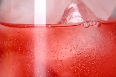 Photo of Glass of refreshing drink with ice cubes as background, closeup