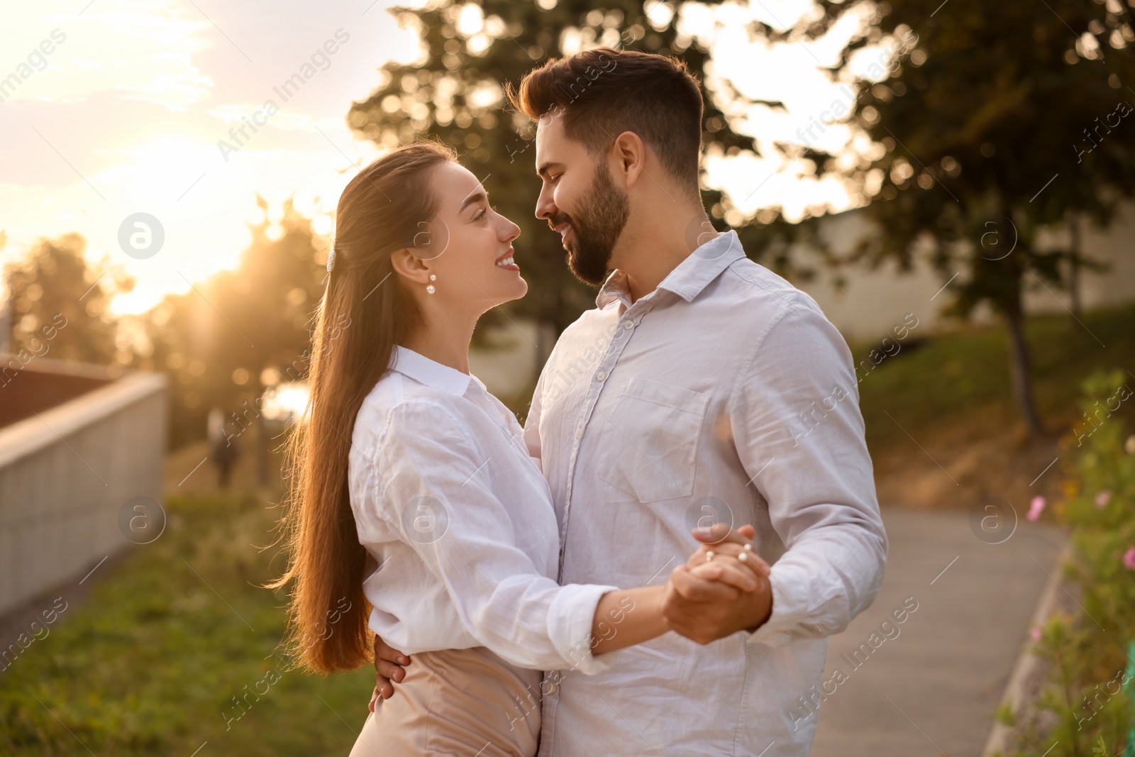 Photo of Lovely couple dancing together outdoors at sunset