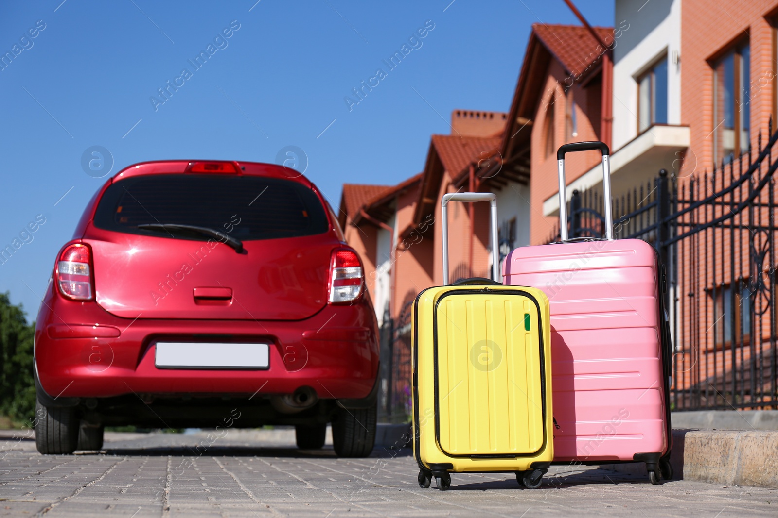 Photo of Color suitcases near family car in city. Summer vacation