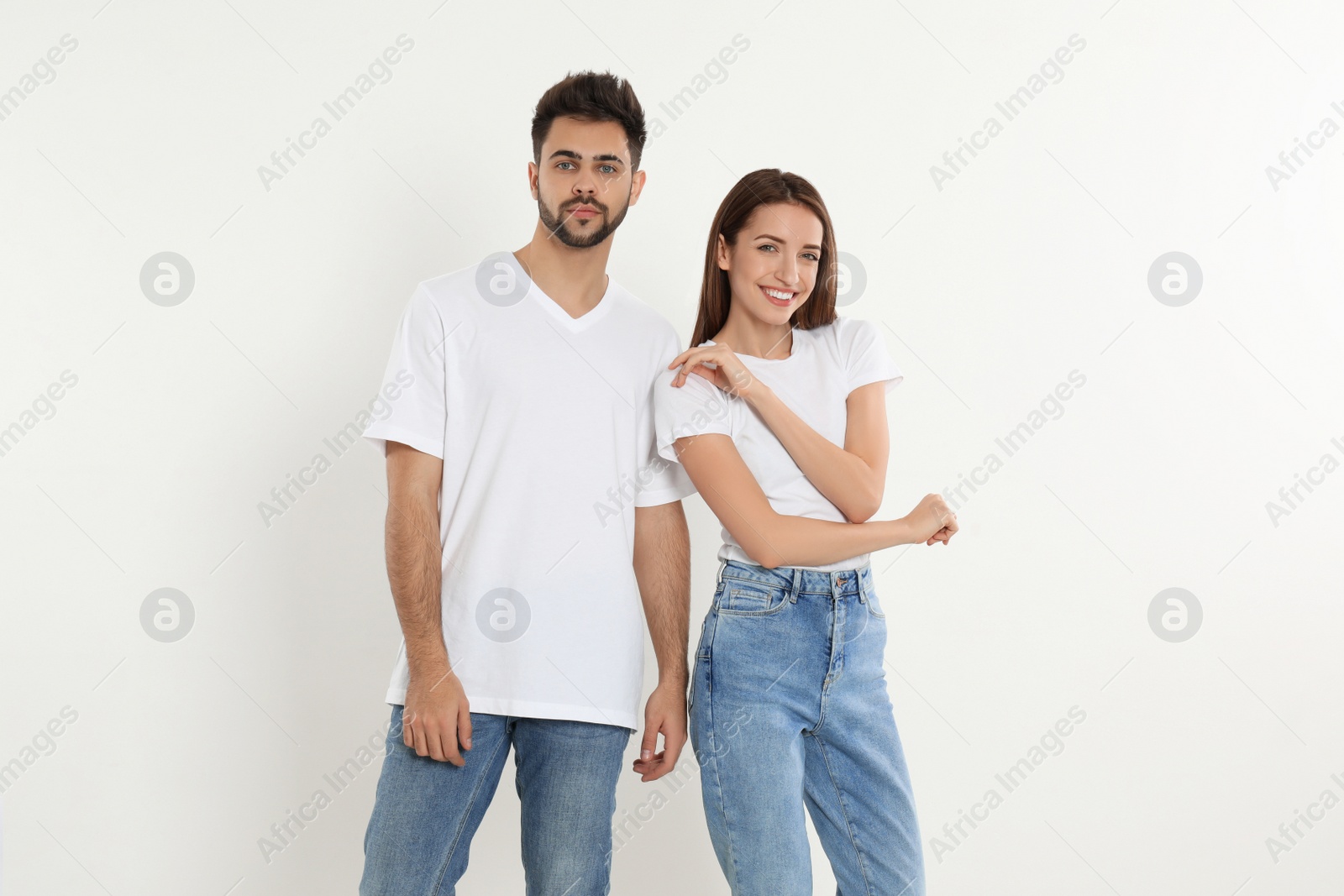 Photo of Young couple in stylish jeans on white background