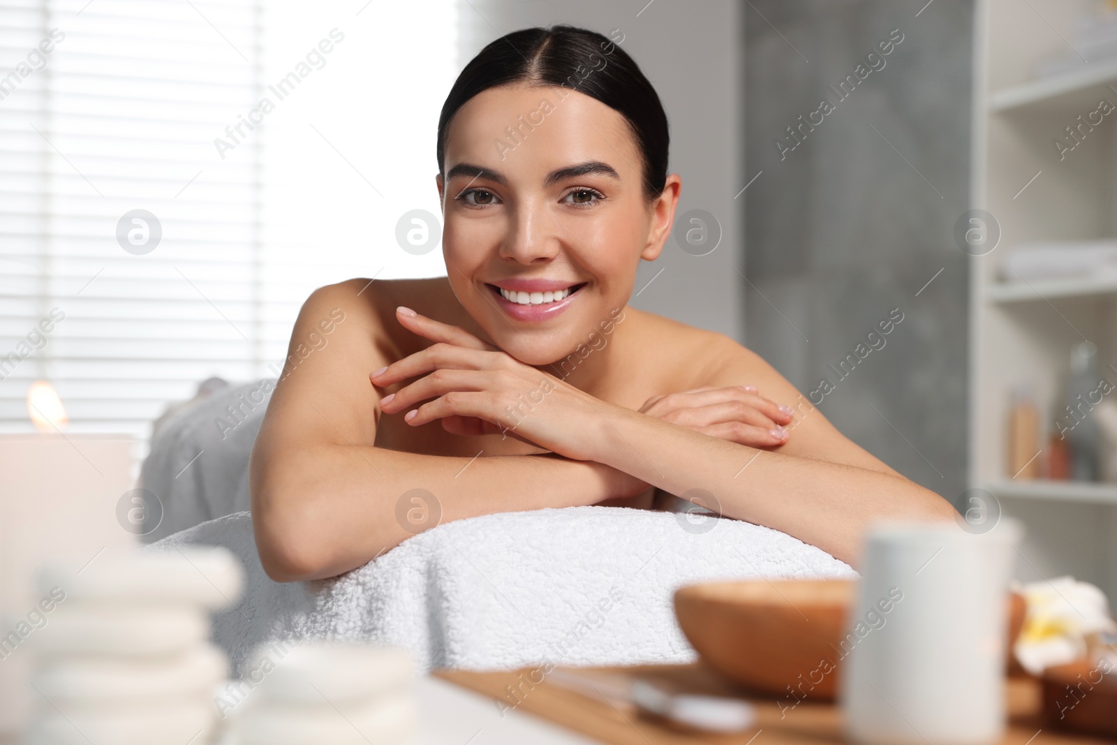 Photo of Beautiful woman relaxing on massage table in spa salon