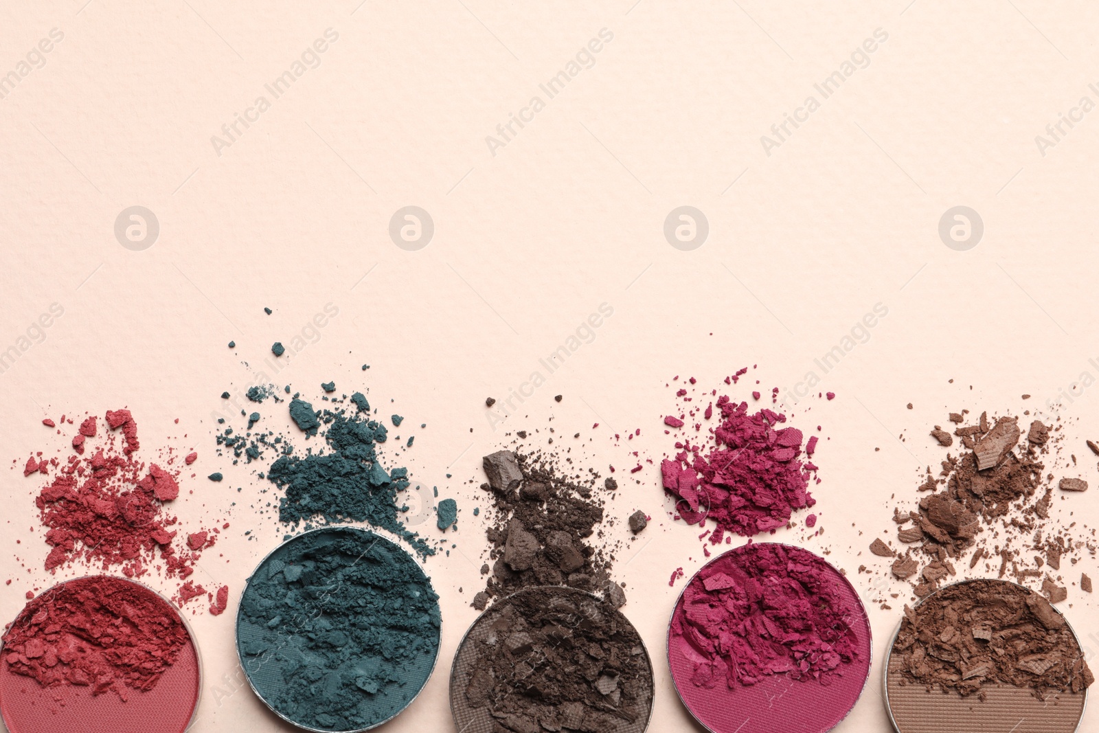 Photo of Different crushed eye shadows on beige background, flat lay. Space for text