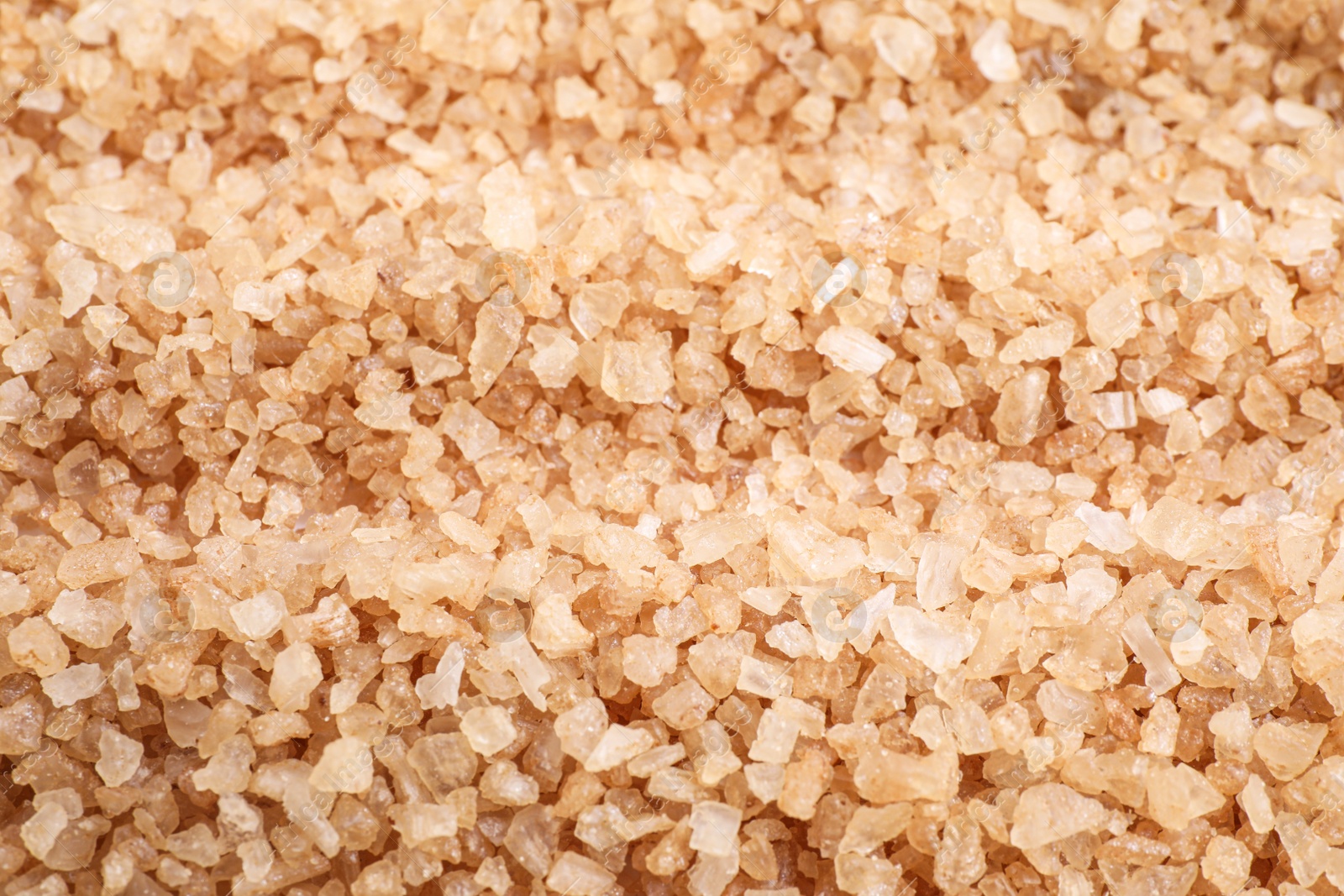 Photo of Brown sea salt as background, closeup. Spa treatment