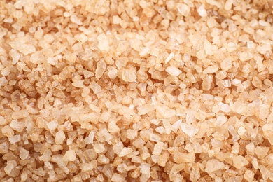 Photo of Brown sea salt as background, closeup. Spa treatment