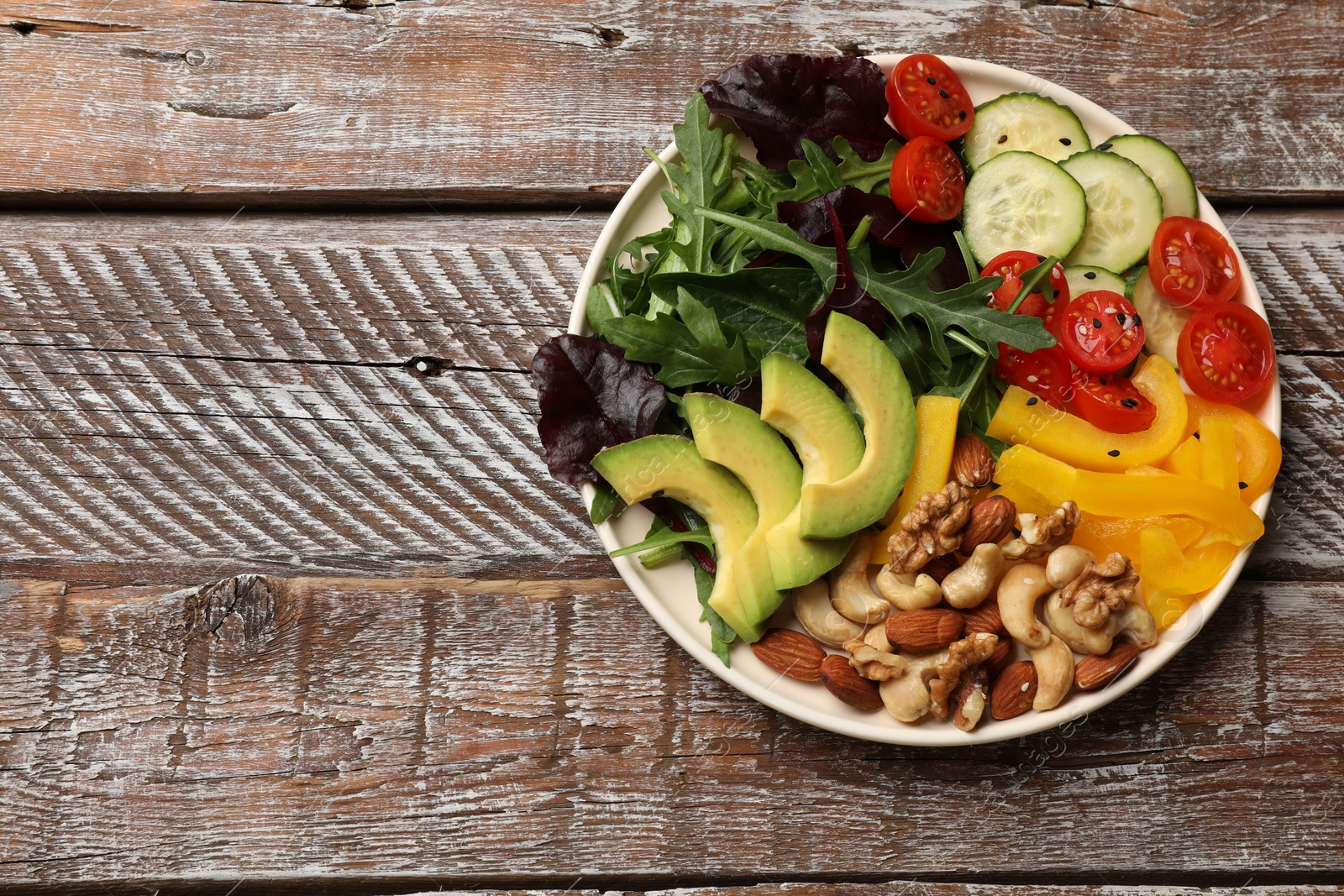 Photo of Balanced diet and vegetarian foods. Plate with different delicious products on wooden table, top view. Space for text