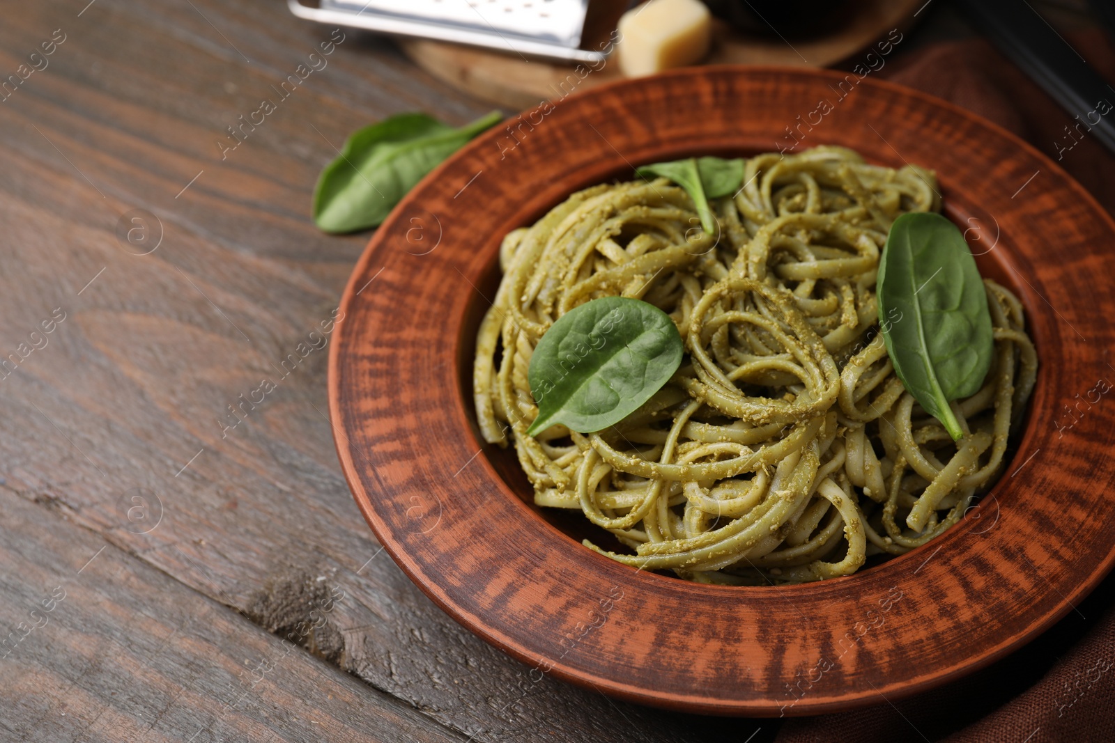 Photo of Tasty pasta with spinach on wooden table, space for text