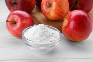Sweet powdered fructose and fresh apples on white wooden table, closeup