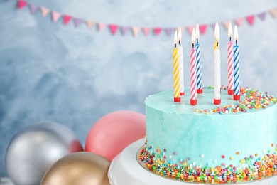 Photo of Fresh delicious birthday cake with candles near balloons on color background. Space for text