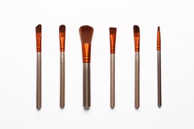 Photo of Set of makeup brushes on white background, flat lay
