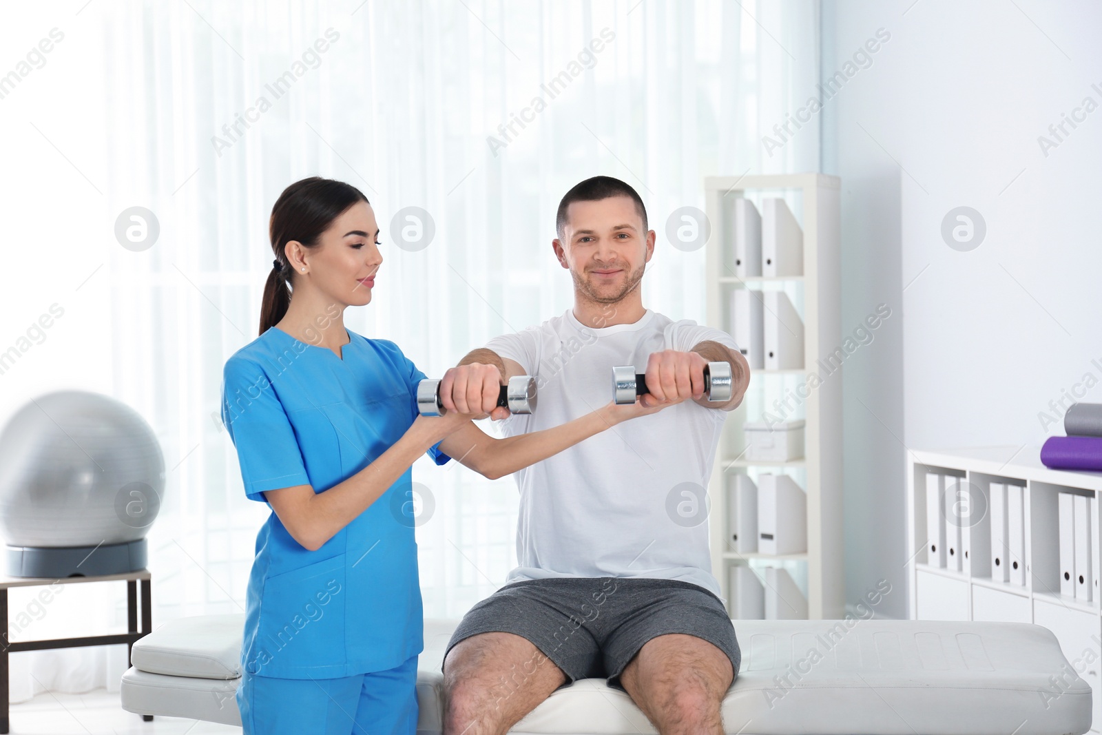 Photo of Doctor working with patient in hospital. Rehabilitation exercises