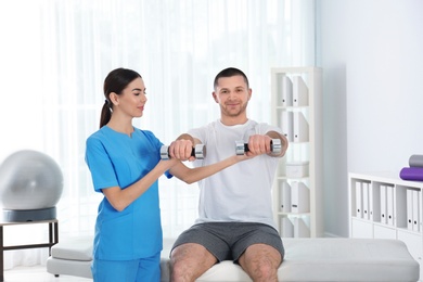 Photo of Doctor working with patient in hospital. Rehabilitation exercises