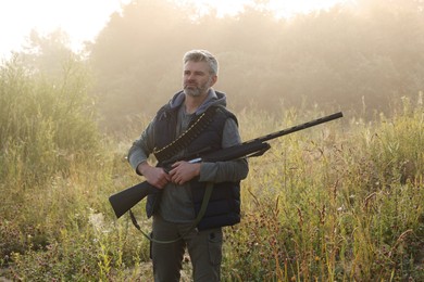 Photo of Man with hunting rifle outdoors. Open season