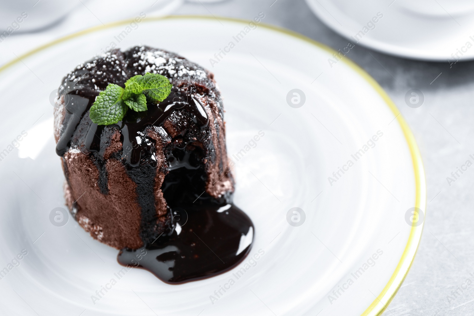 Photo of Delicious warm chocolate lava cake on plate, closeup