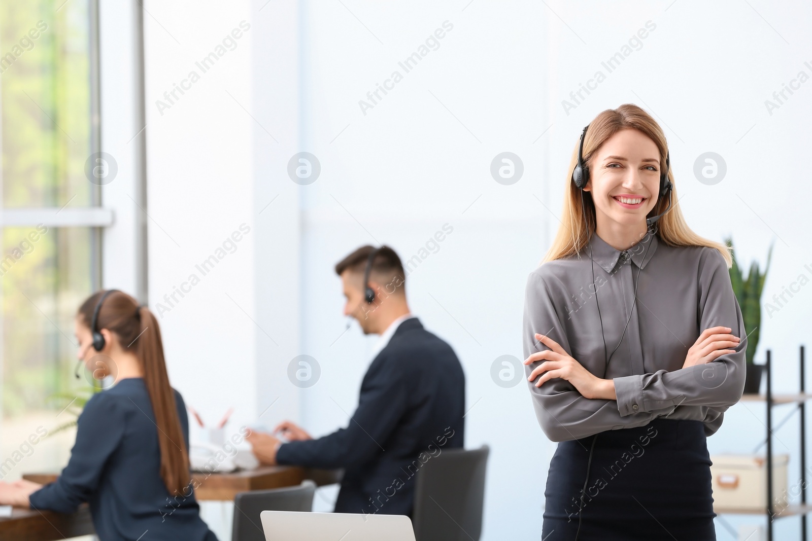 Photo of Young female receptionist with headset in office