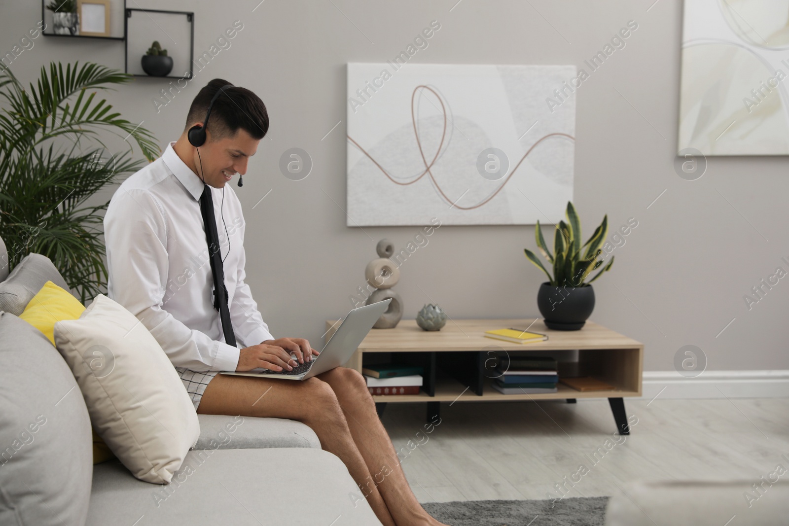 Photo of Man working on laptop in living room. Stay at home concept